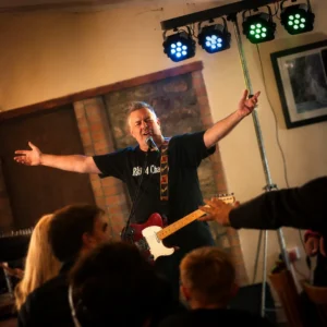 Live musician performing on stage during a private celebration and corporate event at Bandpitt Barn