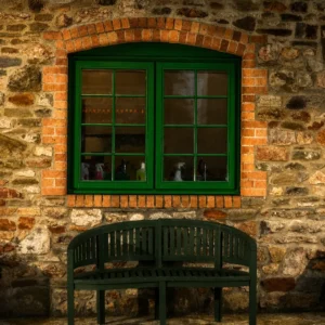 A quiet green bench against a traditional stone wall at Bandpitt Barn, a peaceful corporate conference venue in the Mendips